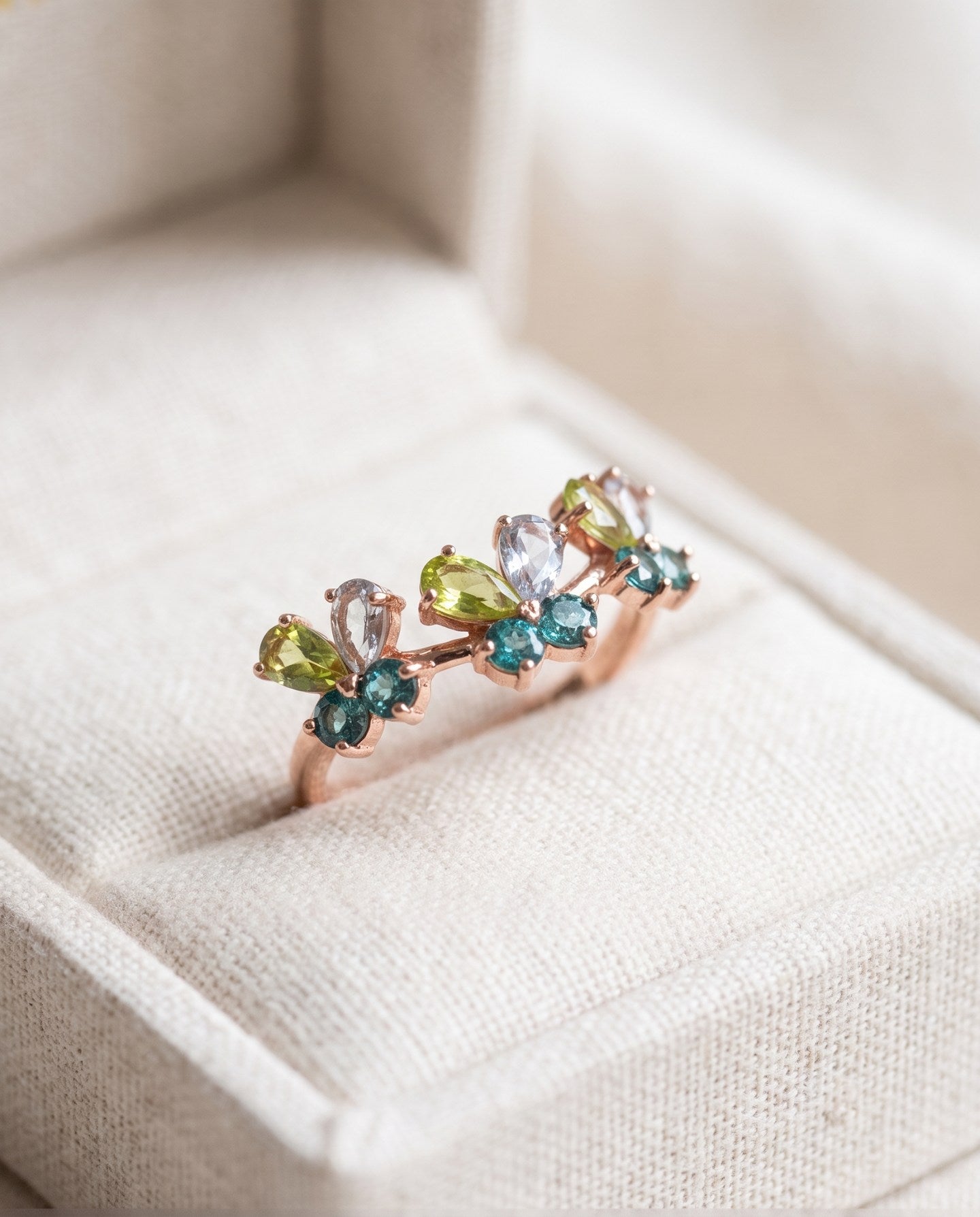 Papillon Butterfly Meadow Ring in rose gold with peridot and blue topaz butterflies on a light neutral background