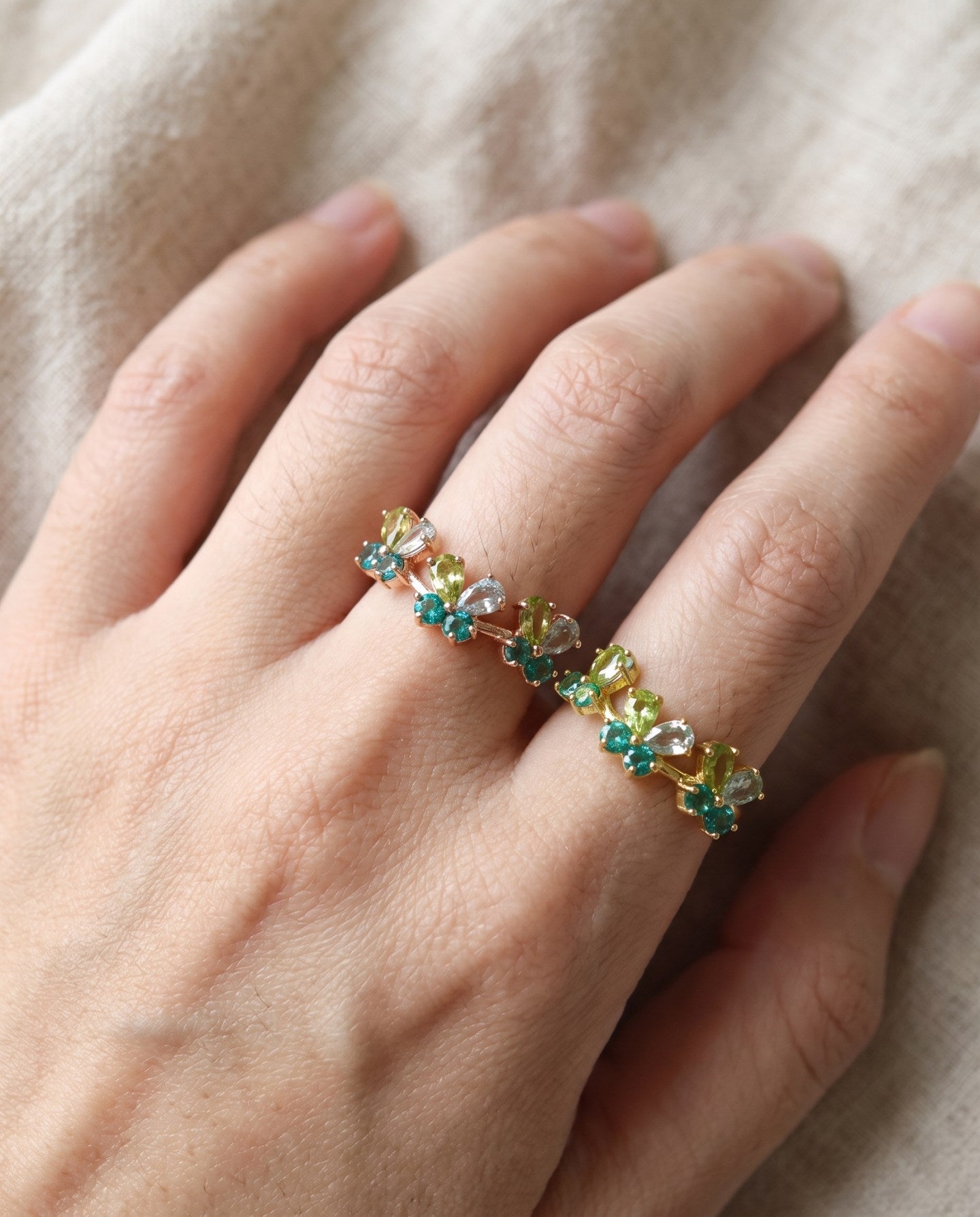 Papillon Butterfly Meadow Ring in rose gold with peridot and blue topaz butterflies worn on the hand