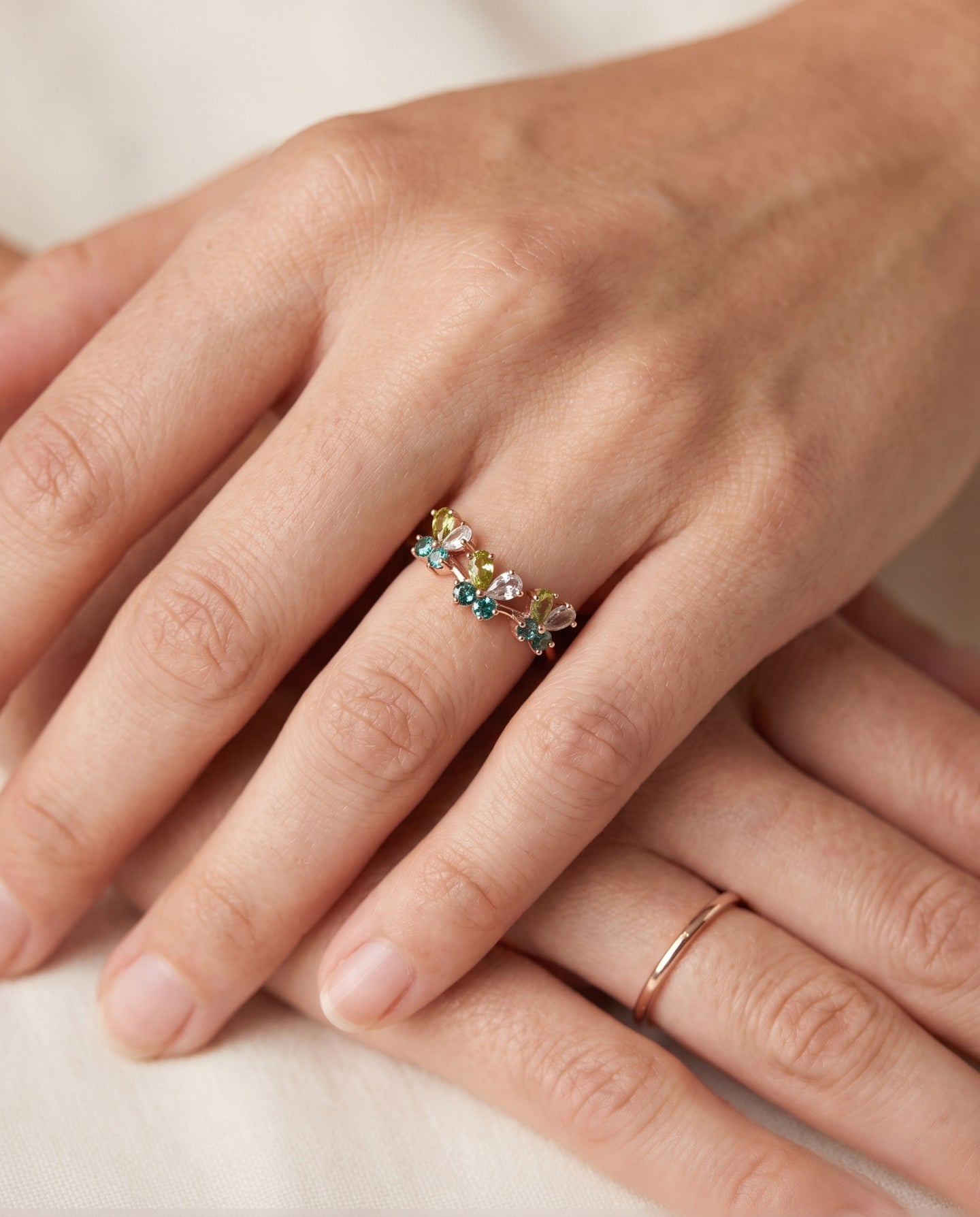 Papillon Butterfly Meadow Ring in rose gold with peridot and blue topaz butterflies worn on the hand