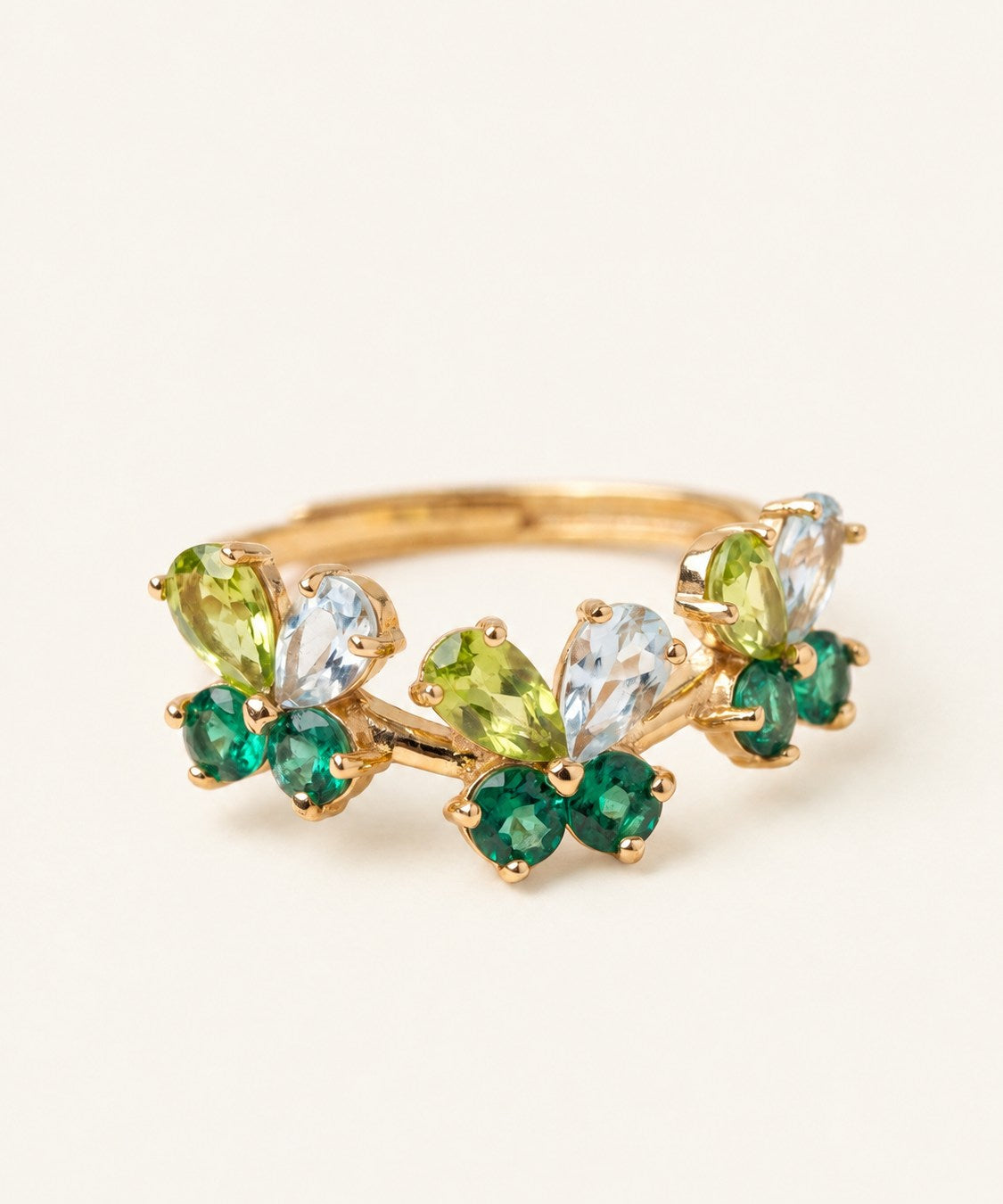 Papillon Butterfly Meadow Ring in yellow gold with peridot and blue topaz butterflies on a light neutral background