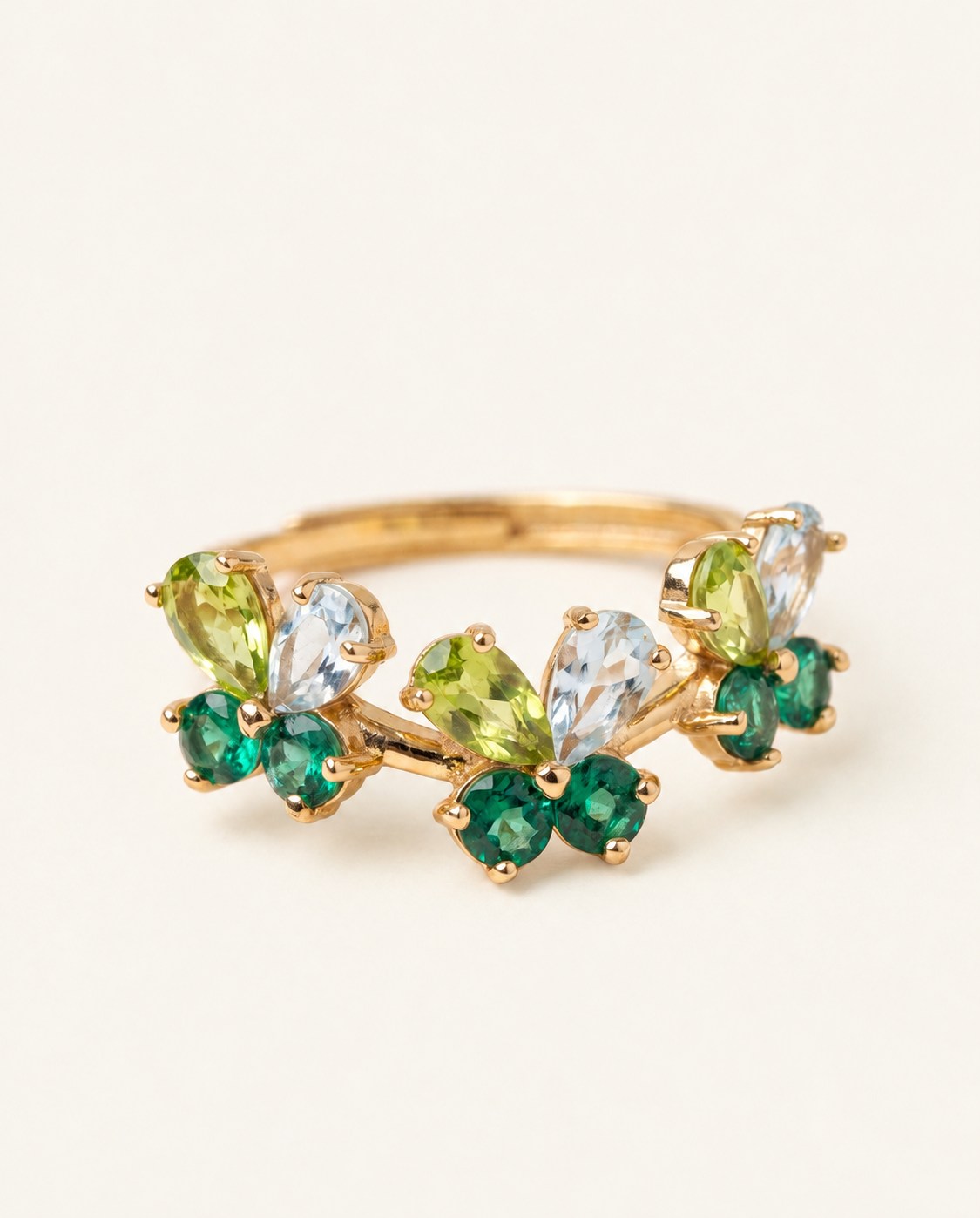Papillon Butterfly Meadow Ring in yellow gold with peridot and blue topaz butterflies on a light neutral background