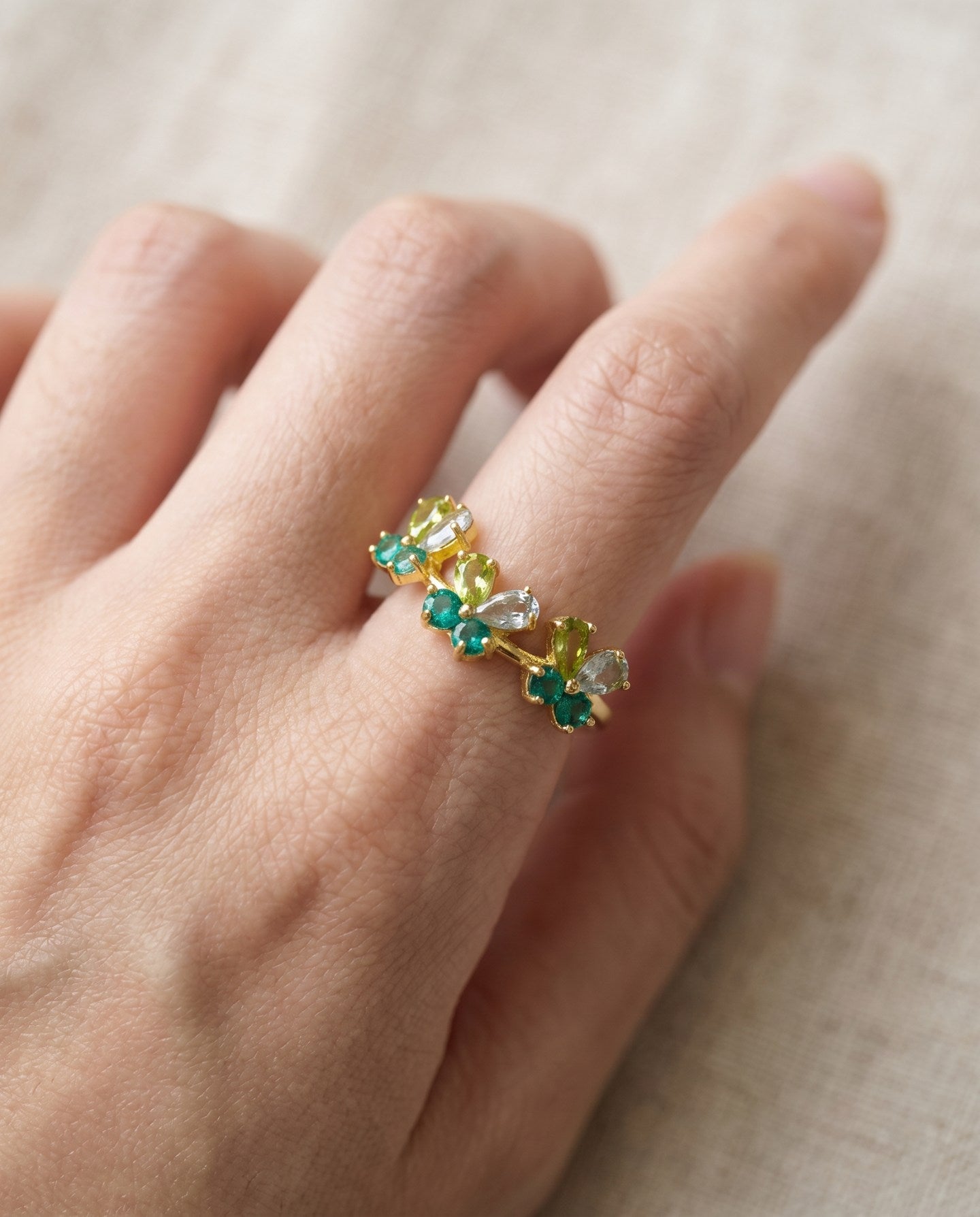 Papillon Butterfly Meadow Ring in yellow gold with peridot and blue topaz butterflies worn on the hand