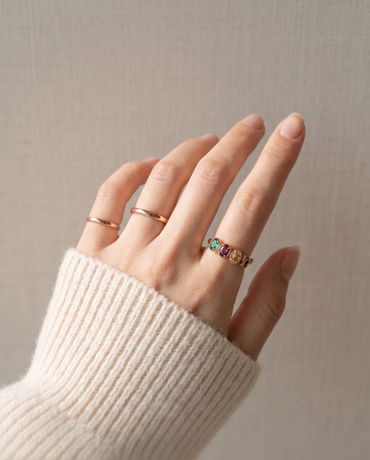Papillon Trio Gemstone Ring in rose gold, worn knit sleeve