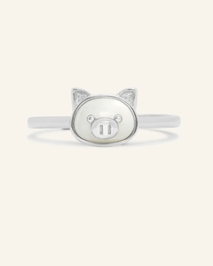 Close-up of the Pig Zodiac Ring in Mother of Pearl, resting on a warm linen background