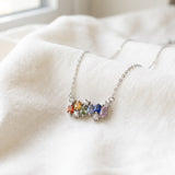 Prism Baguette Rainbow Sapphire Necklace in silver with six multicolour natural sapphires on a neutral ivory background