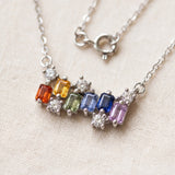 Prism Baguette Rainbow Sapphire Necklace in silver with six multicolour natural sapphires on a neutral ivory background