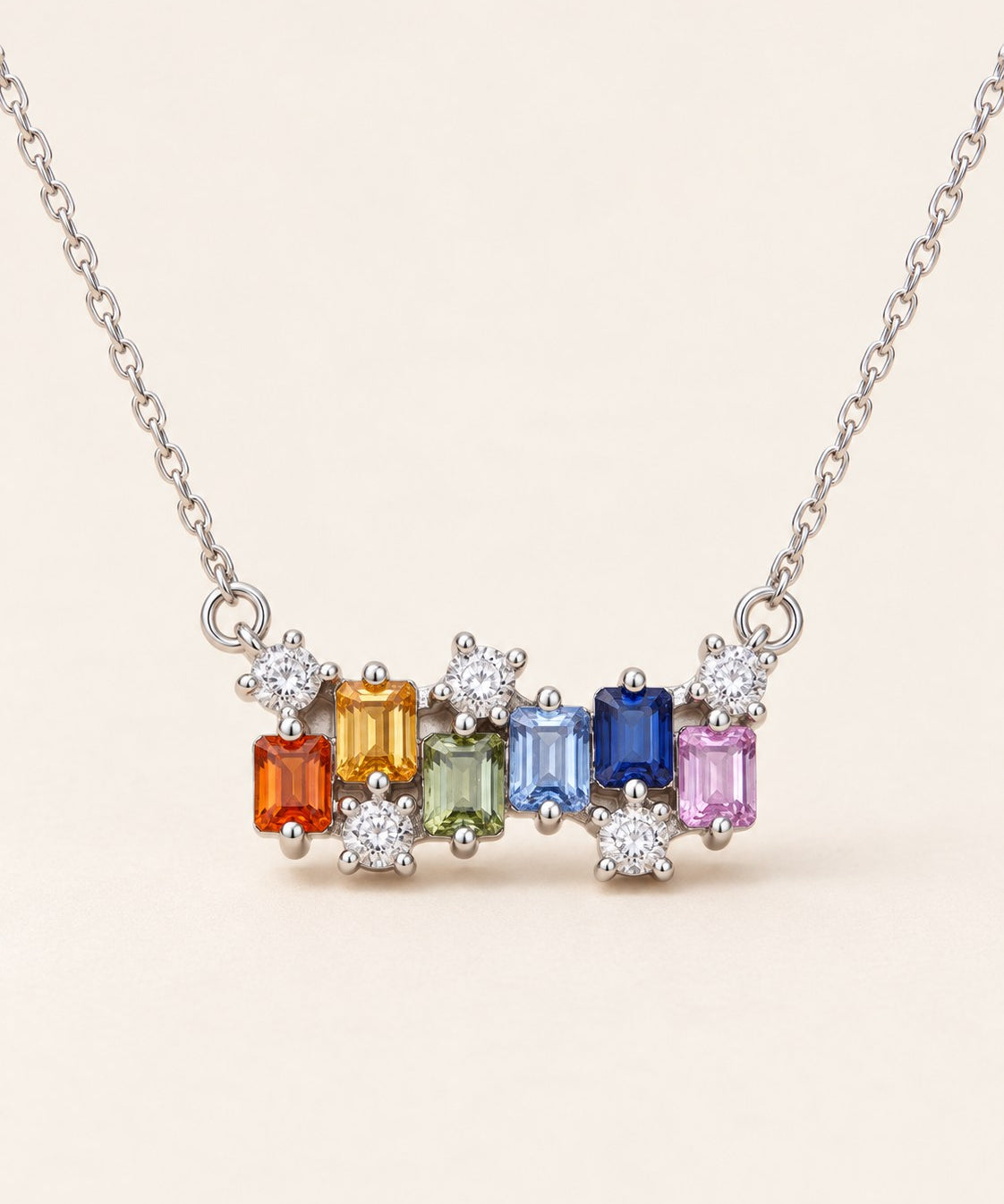 Prism Baguette Rainbow Sapphire Necklace in silver with six multicolour natural sapphires on a neutral ivory background