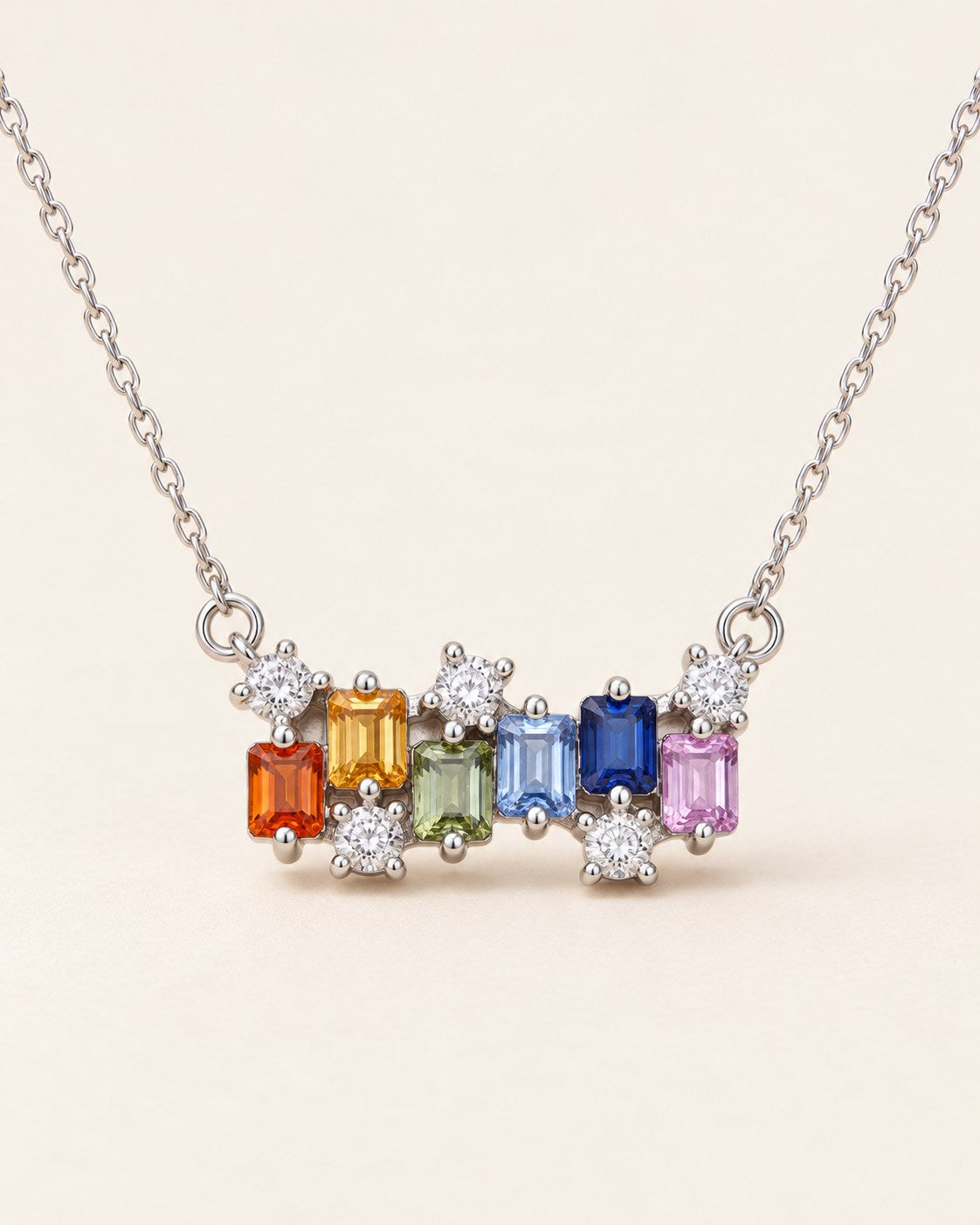 Prism Baguette Rainbow Sapphire Necklace in silver with six multicolour natural sapphires on a neutral ivory background