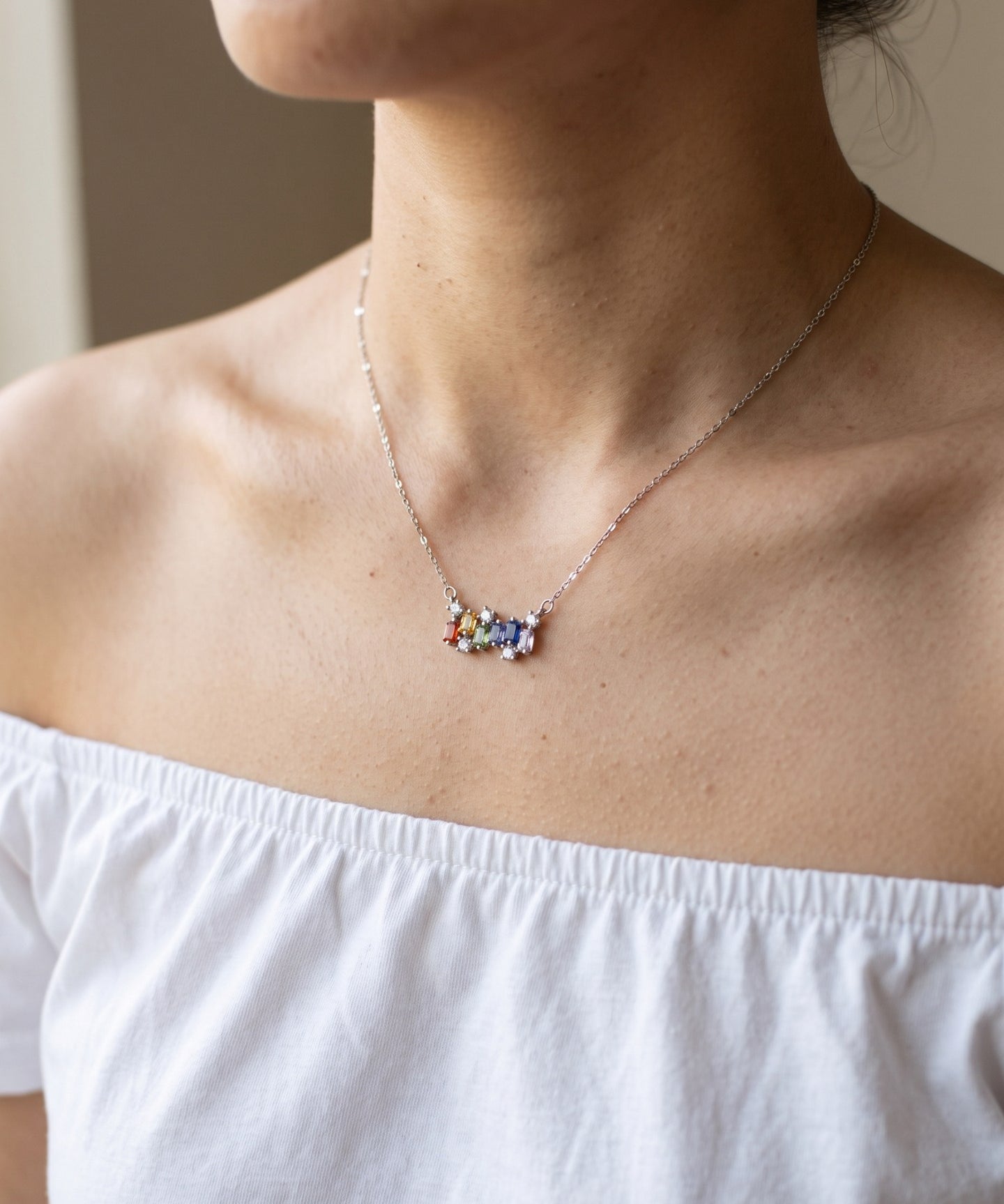 Prism Baguette Rainbow Sapphire Necklace in silver with six multicolour natural sapphires worn at the collarbone