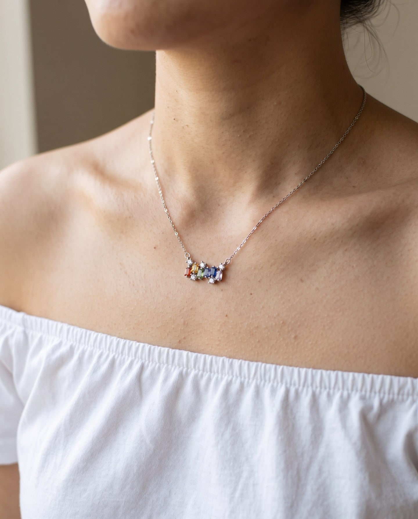 Prism Baguette Rainbow Sapphire Necklace in silver with six multicolour natural sapphires worn at the collarbone