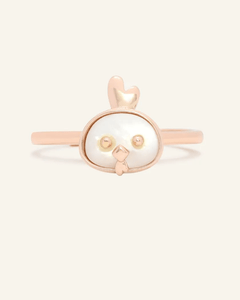 Close-up of the Rooster Zodiac Ring in Mother of Pearl, resting on a warm linen background