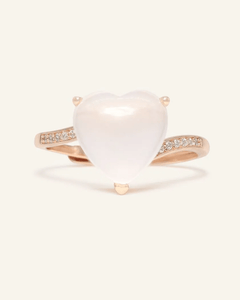 Close-up of the Rose Quartz Heart Ring, resting on a warm linen background