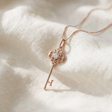 Memoir Grey Moissanite Key Necklace in rose gold, styled on neutral fabric