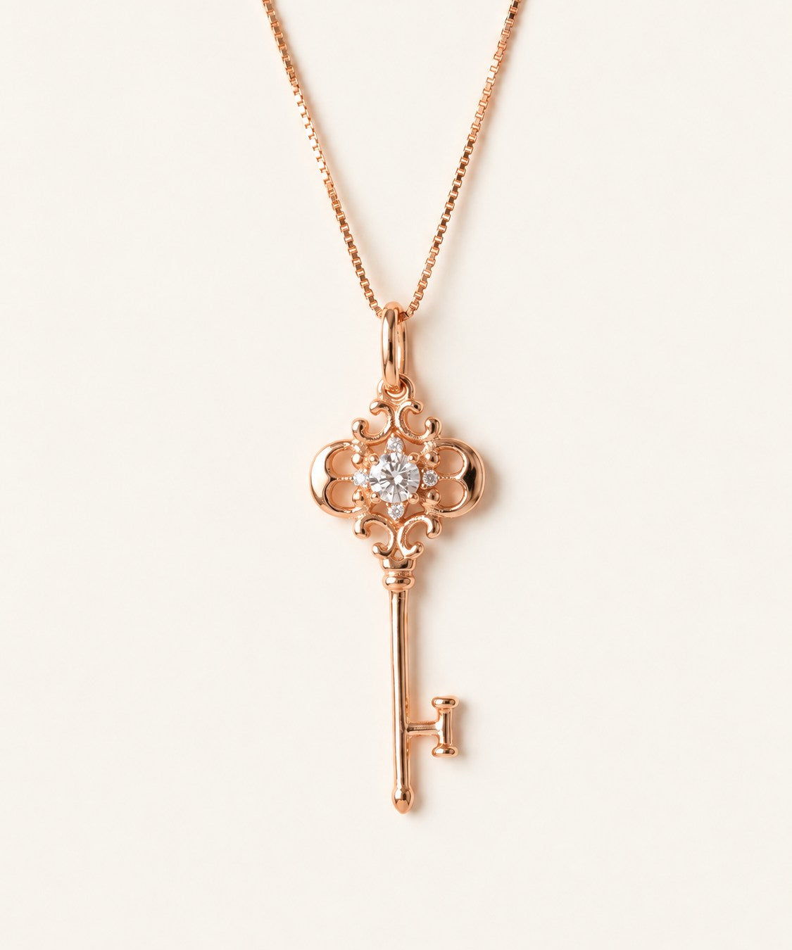 Memoir Grey Moissanite Key Necklace in rose gold, ornate filigree key pendant on warm ivory