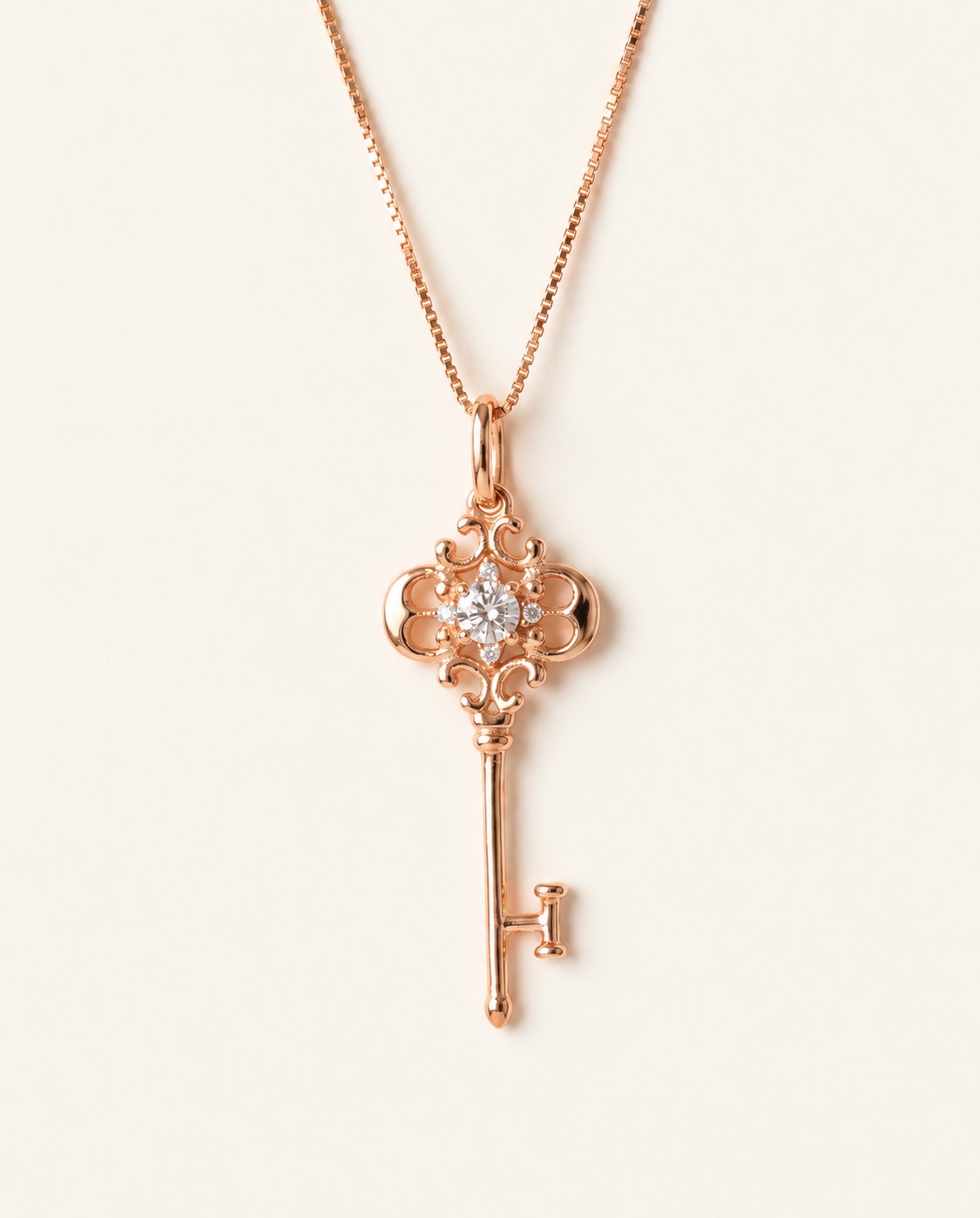 Memoir Grey Moissanite Key Necklace in rose gold, ornate filigree key pendant on warm ivory