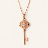 Memoir Grey Moissanite Key Necklace in rose gold, ornate filigree key pendant on warm ivory