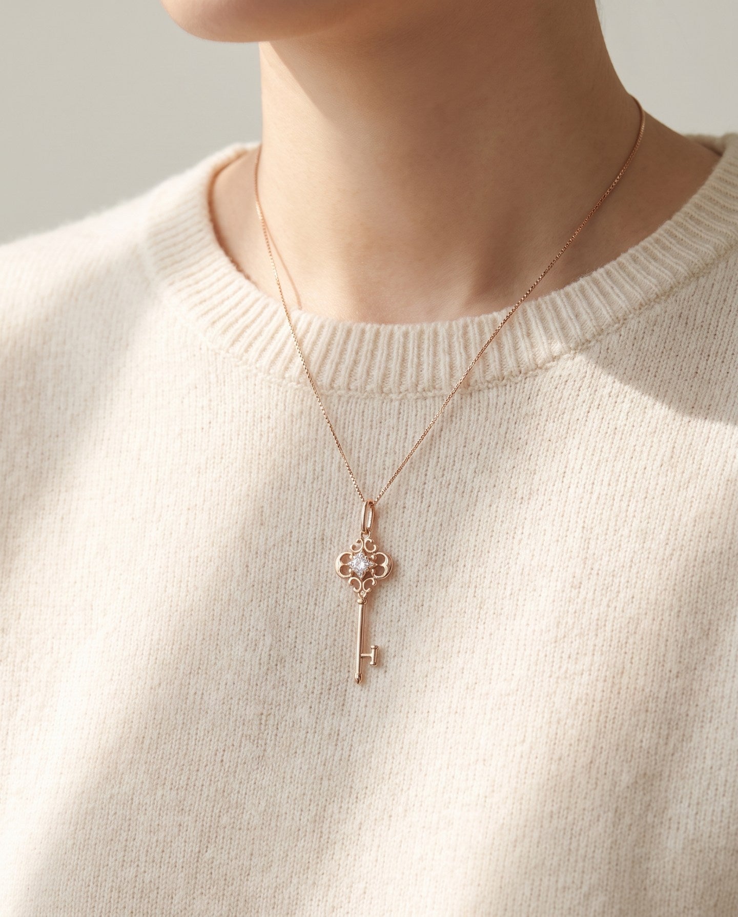 Memoir Grey Moissanite Key Necklace in rose gold, worn on a delicate chain in natural light