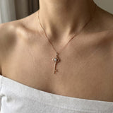 Memoir Grey Moissanite Key Necklace in rose gold, worn on a delicate chain in natural light