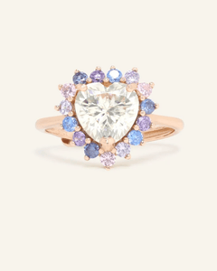 Serenity Heart Moissanite Ring in rose gold, resting on a warm linen background