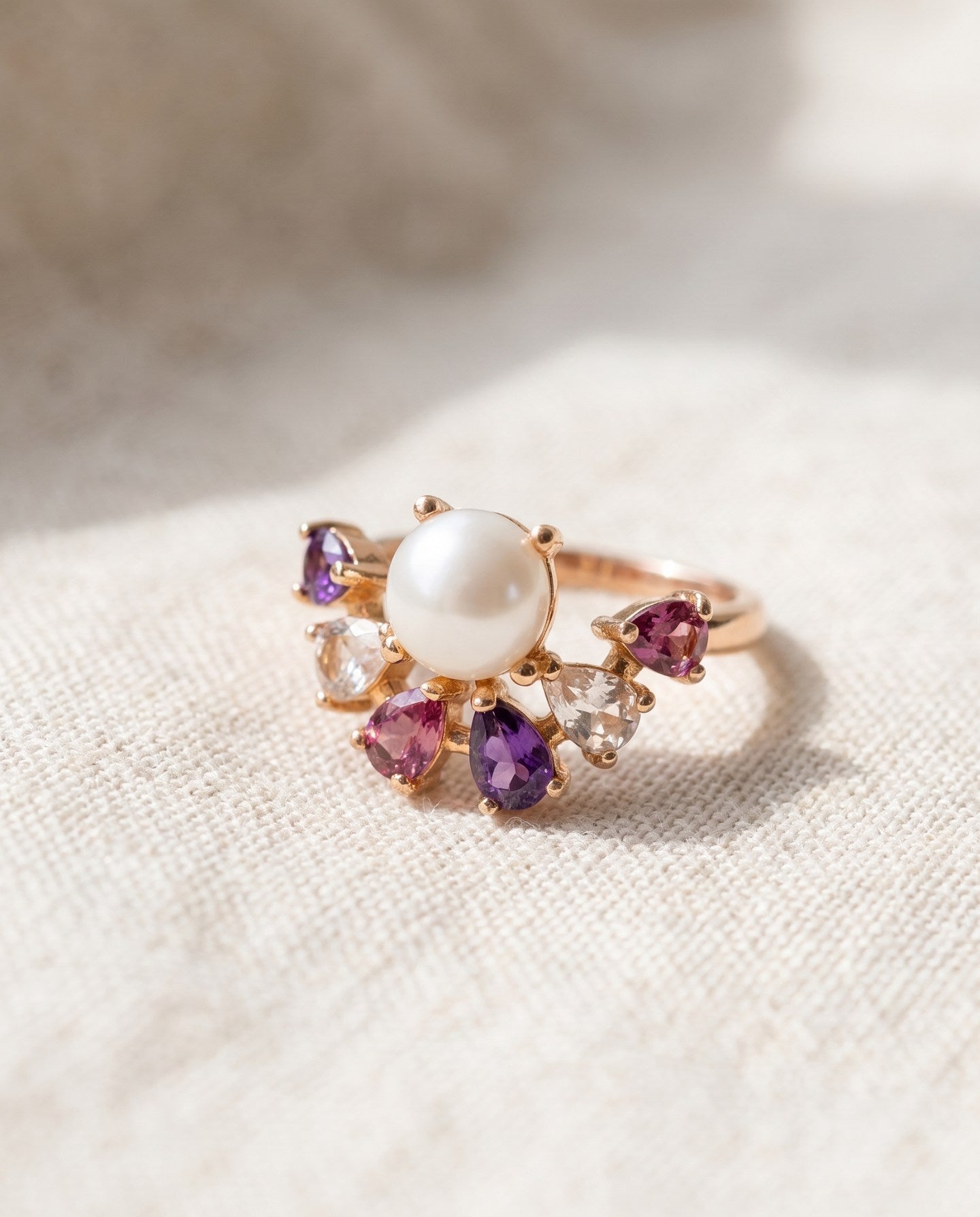 Solstice Pearl & Gemstone Ring in yellow gold on ivory linen, with freshwater pearl and seven pear-cut natural gemstones