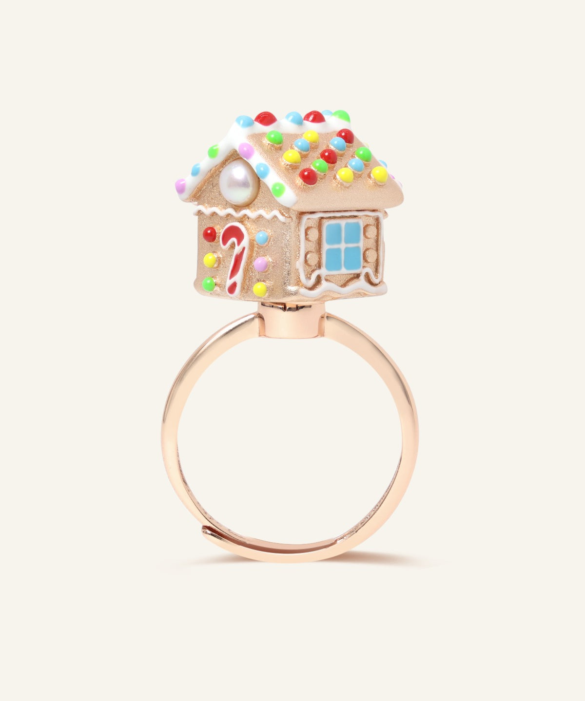 Spinning Gingerbread House Ring in rose gold, angled view showing the candy roof, door and blue window