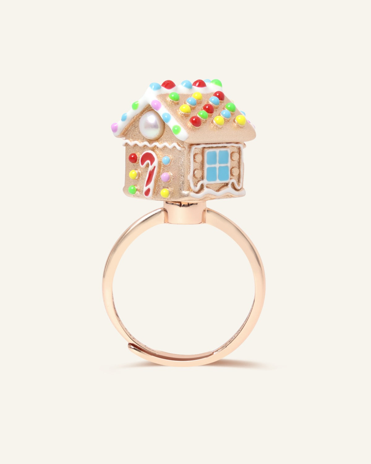 Spinning Gingerbread House Ring in rose gold, angled view showing the candy roof, door and blue window