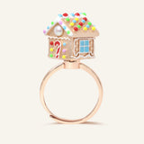 Spinning Gingerbread House Ring in rose gold, angled view showing the candy roof, door and blue window