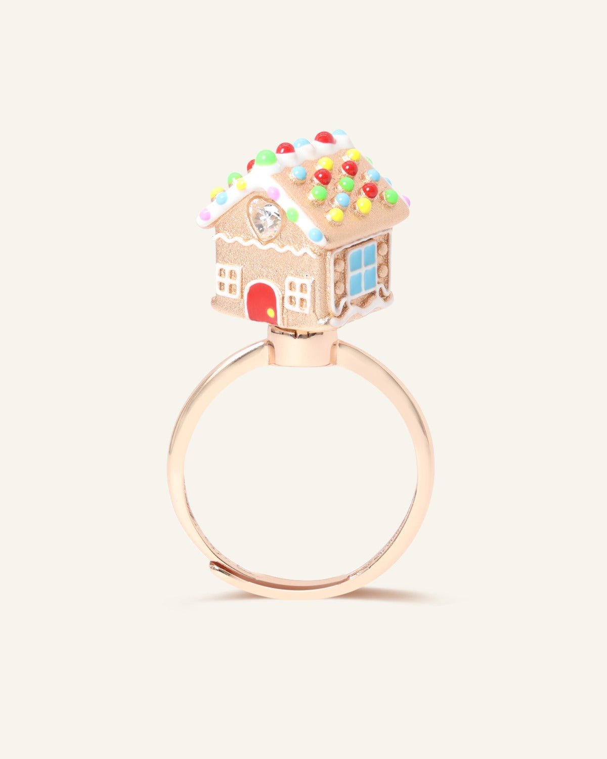 Spinning Gingerbread House Ring in rose gold, front view of the gingerbread house with candy-cane door and blue window