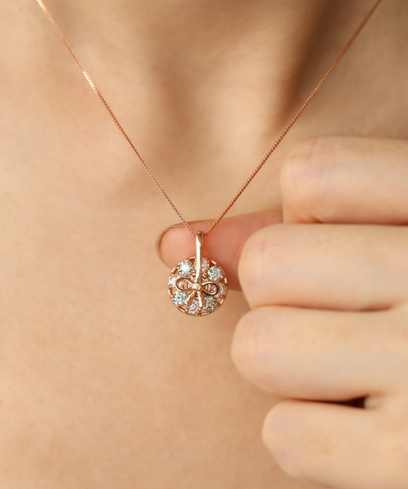 Detail of Green Moissanite and 18k Rose Gold plating on the Spinning Ribbon pendant