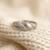 Sugar Sprinkled Croissant Ring in silver, close-up of the pavé band on cream knitted fabric
