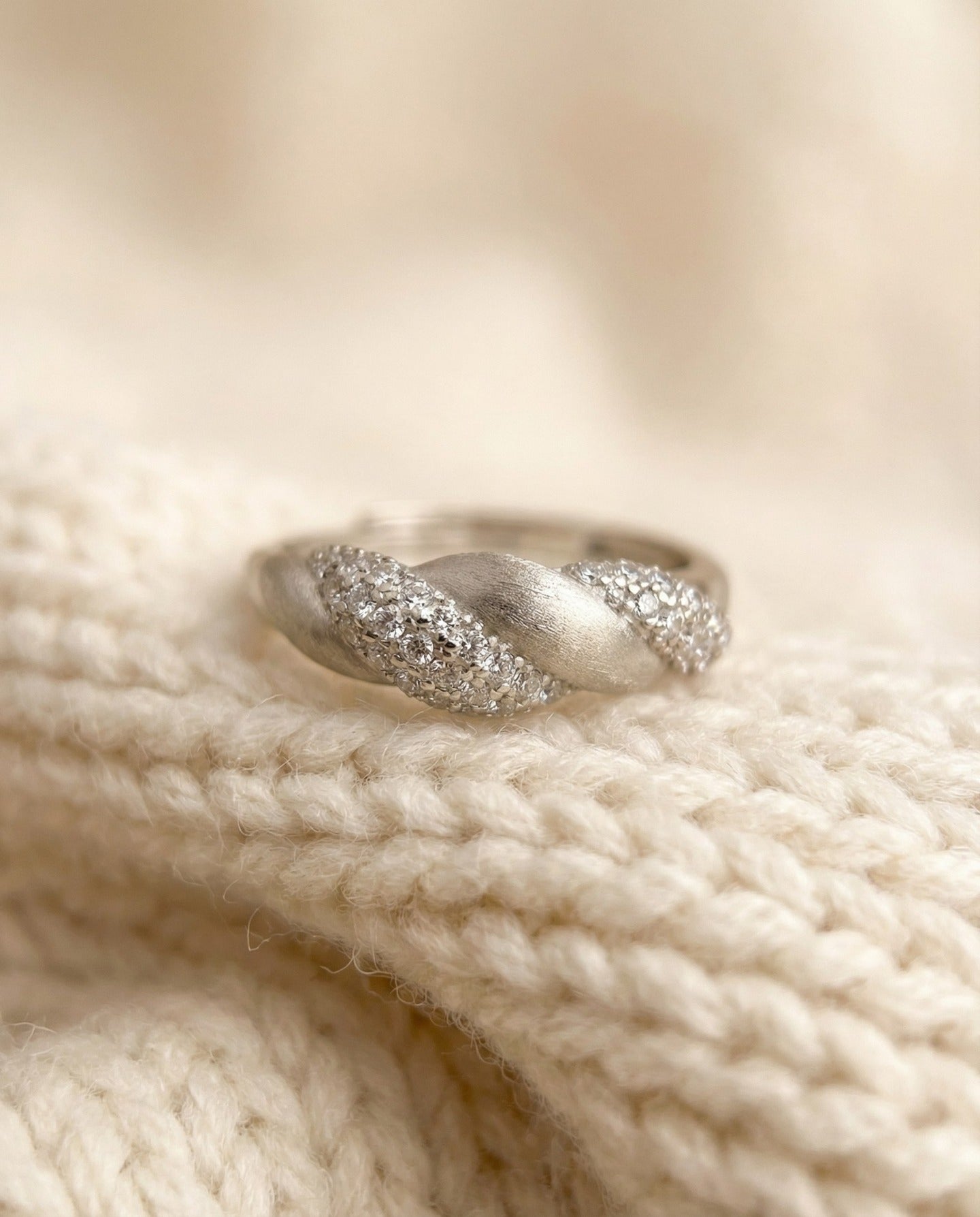 Sugar Sprinkled Croissant Ring in silver, close-up of the pavé band on cream knitted fabric