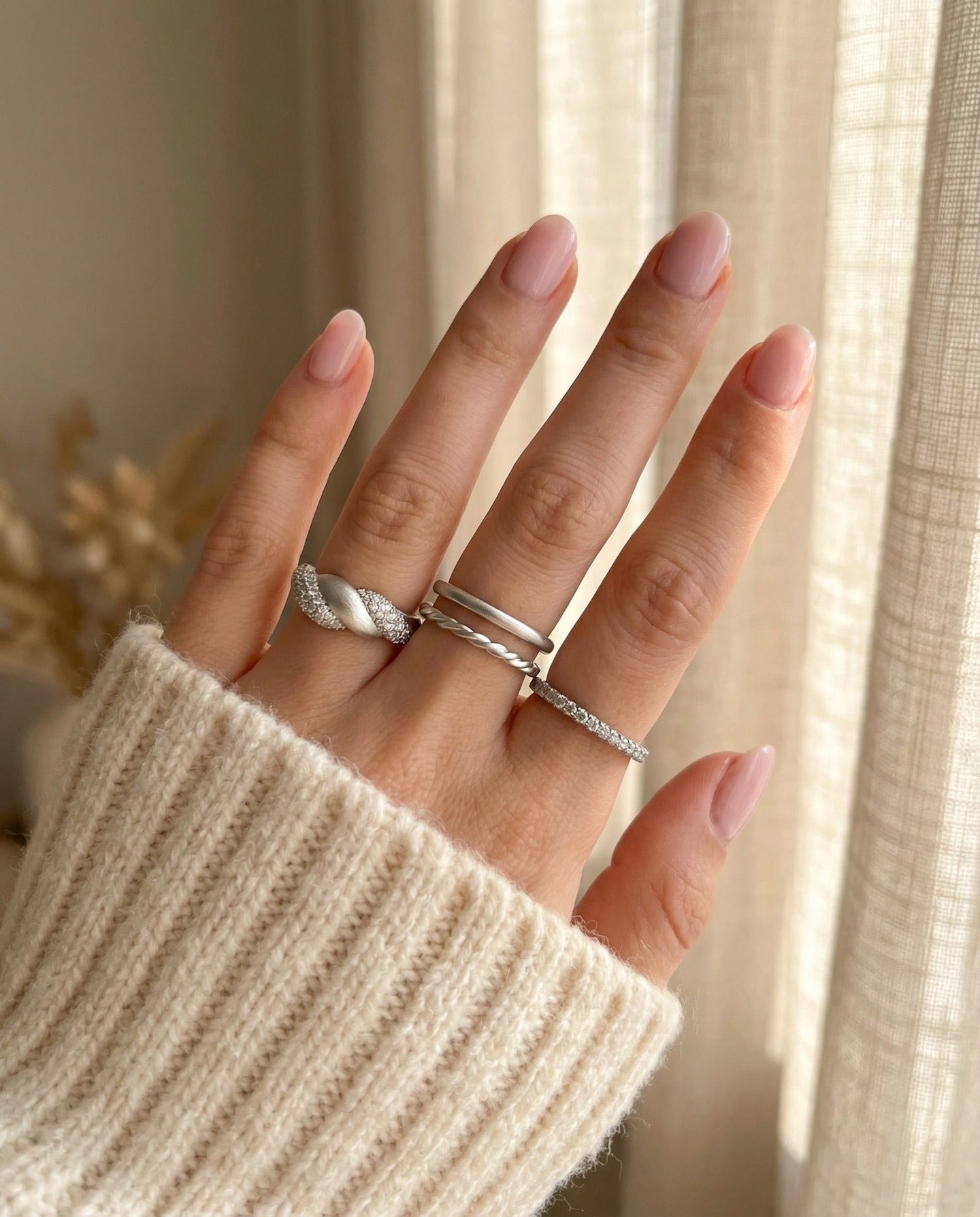Sugar Sprinkled Croissant Ring in silver, worn on an open hand in a silver ring stack