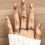 Sugar Sprinkled Croissant Ring in silver, worn on a hand with decorative stacking rings against wood