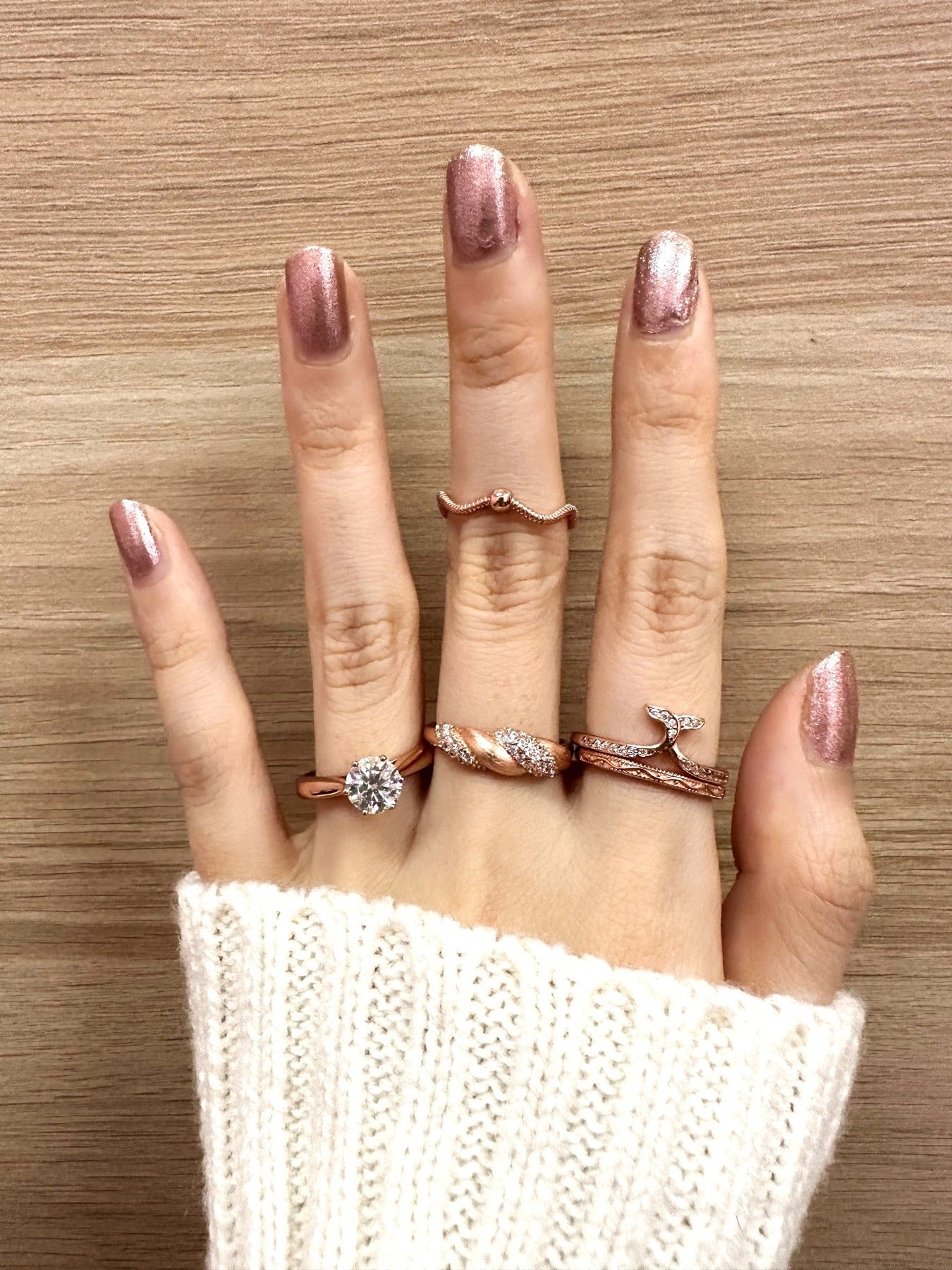 Sugar Sprinkled Croissant Ring in silver, worn on a hand with decorative stacking rings against wood