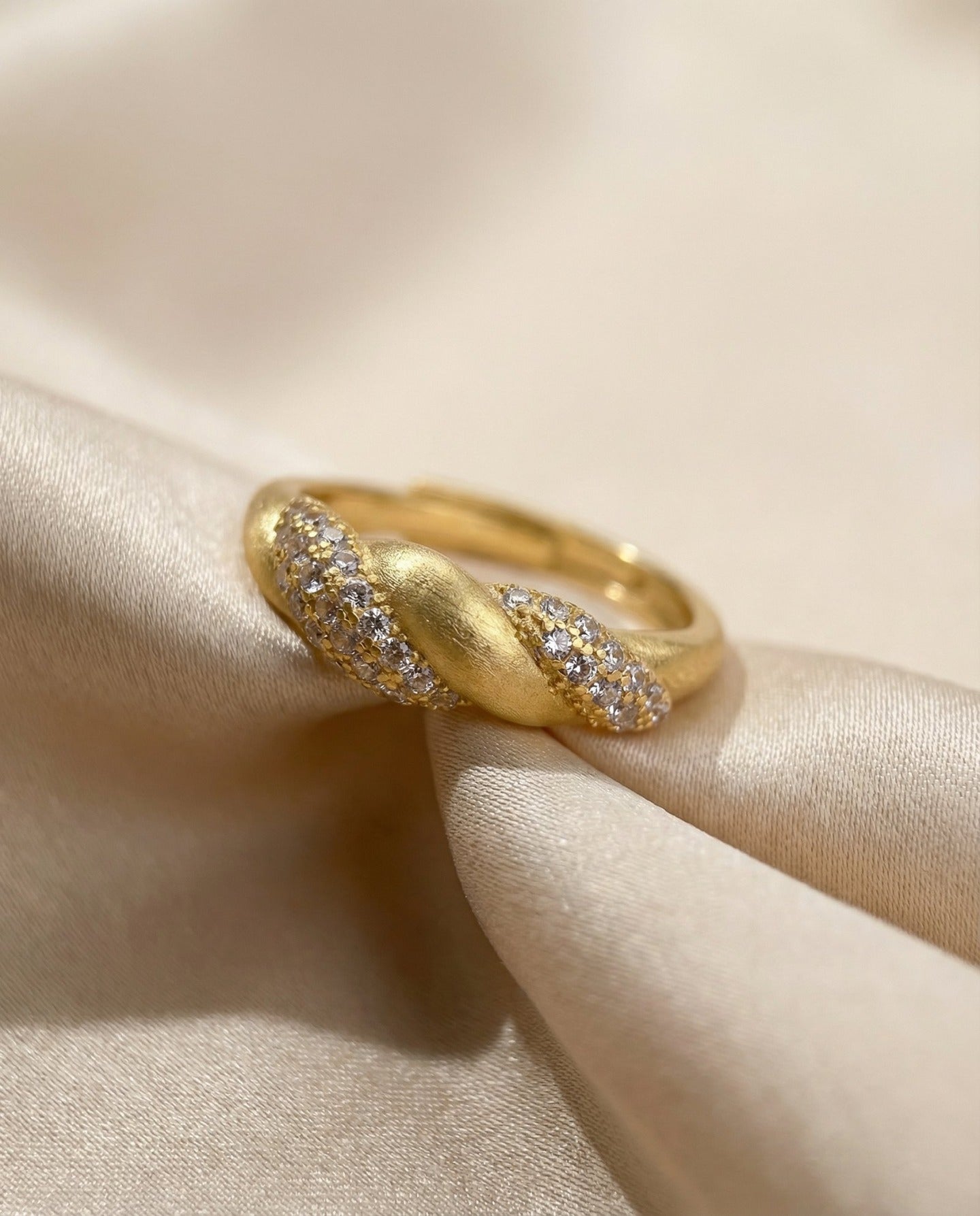Sugar Sprinkled Croissant Ring in yellow gold, angled view on folded ivory fabric