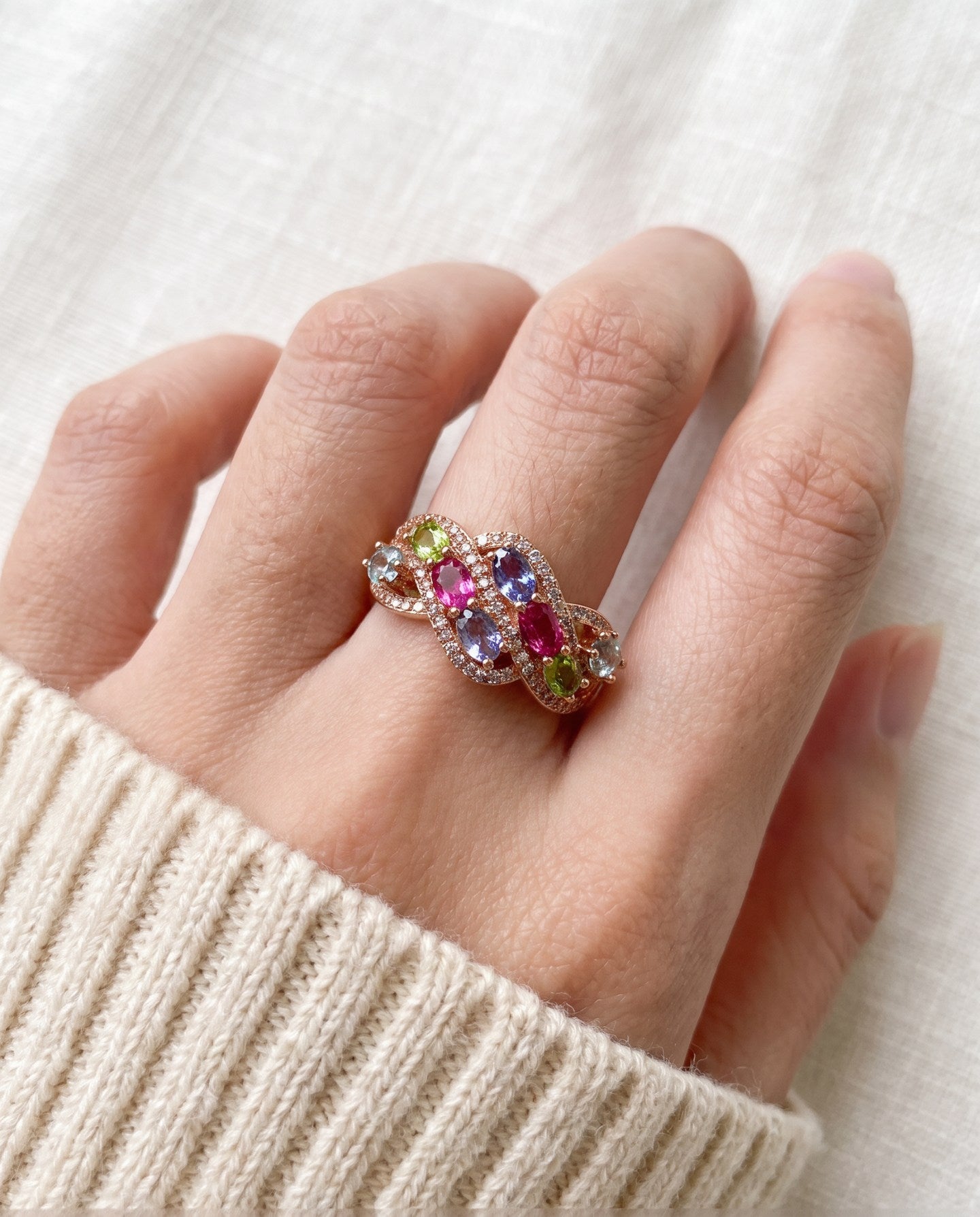 Symphony Wave Multi-Gemstone Ring in rose gold, worn on a hand in natural light