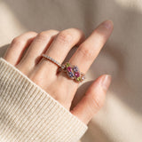 Symphony Wave Multi-Gemstone Ring in rose gold, worn on a hand in natural light